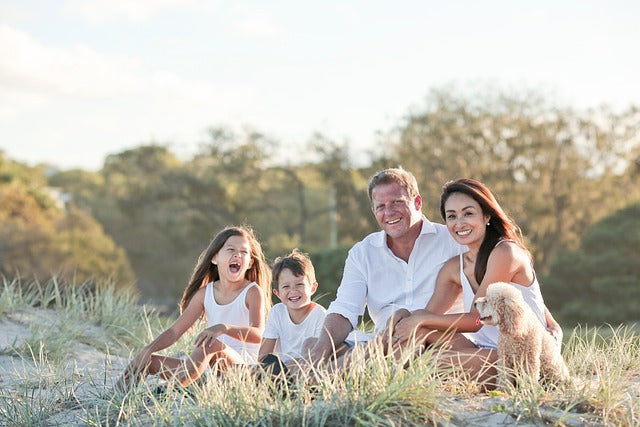 Eine familie von vier sitzt auf einer grasdüne und genießt die natürliche kraft von immune-boosting herbal tea.