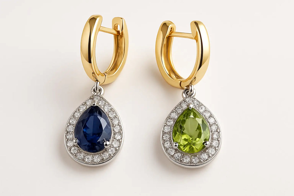Ein Paar elegante goldfarbene creolen mit tropfenförmigen saphir- und peridot-steinen und diamantkranz spirituellen ohrschmuck kaufen mana shop bern