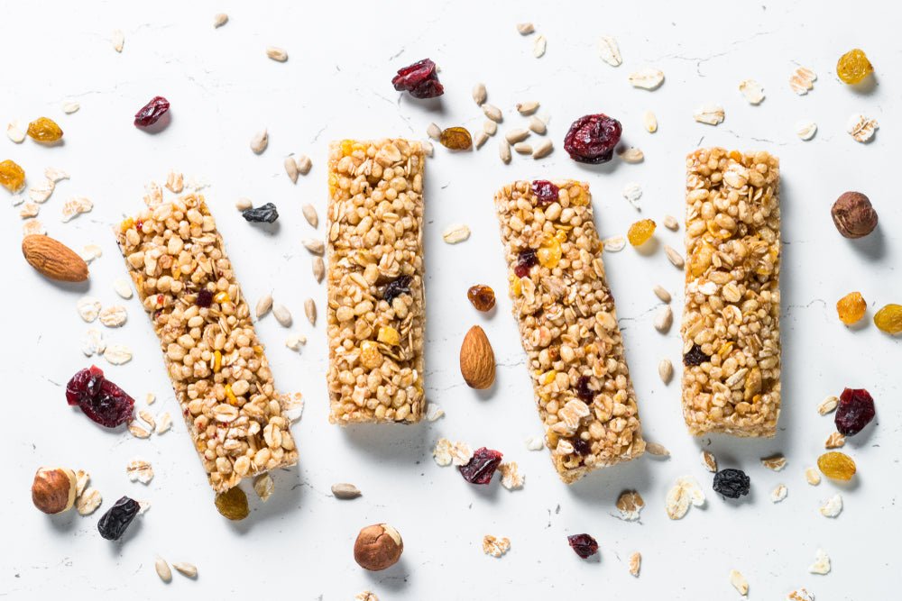 Vier goldbraune granolabars mit getrockneten cranberries und nüssen aus der kollektion gesunde süssigkeiten kaufen