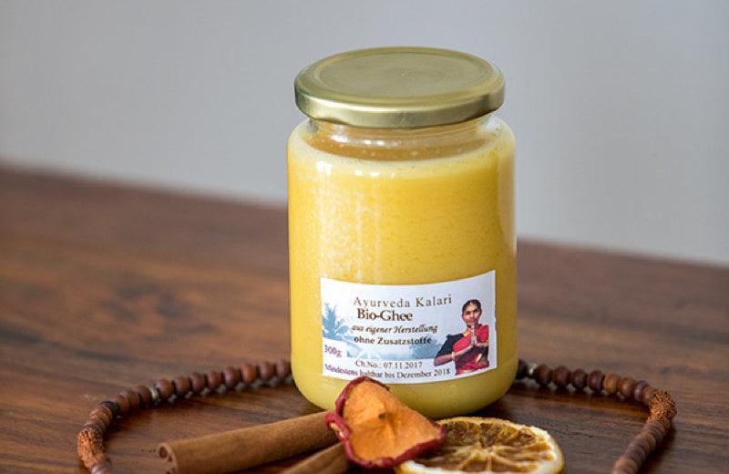 Ayurveda Kalari Bio-Ghee in Glas mit Zimtstangen und getrockneten Zitronenscheiben, natürliche Ernährung