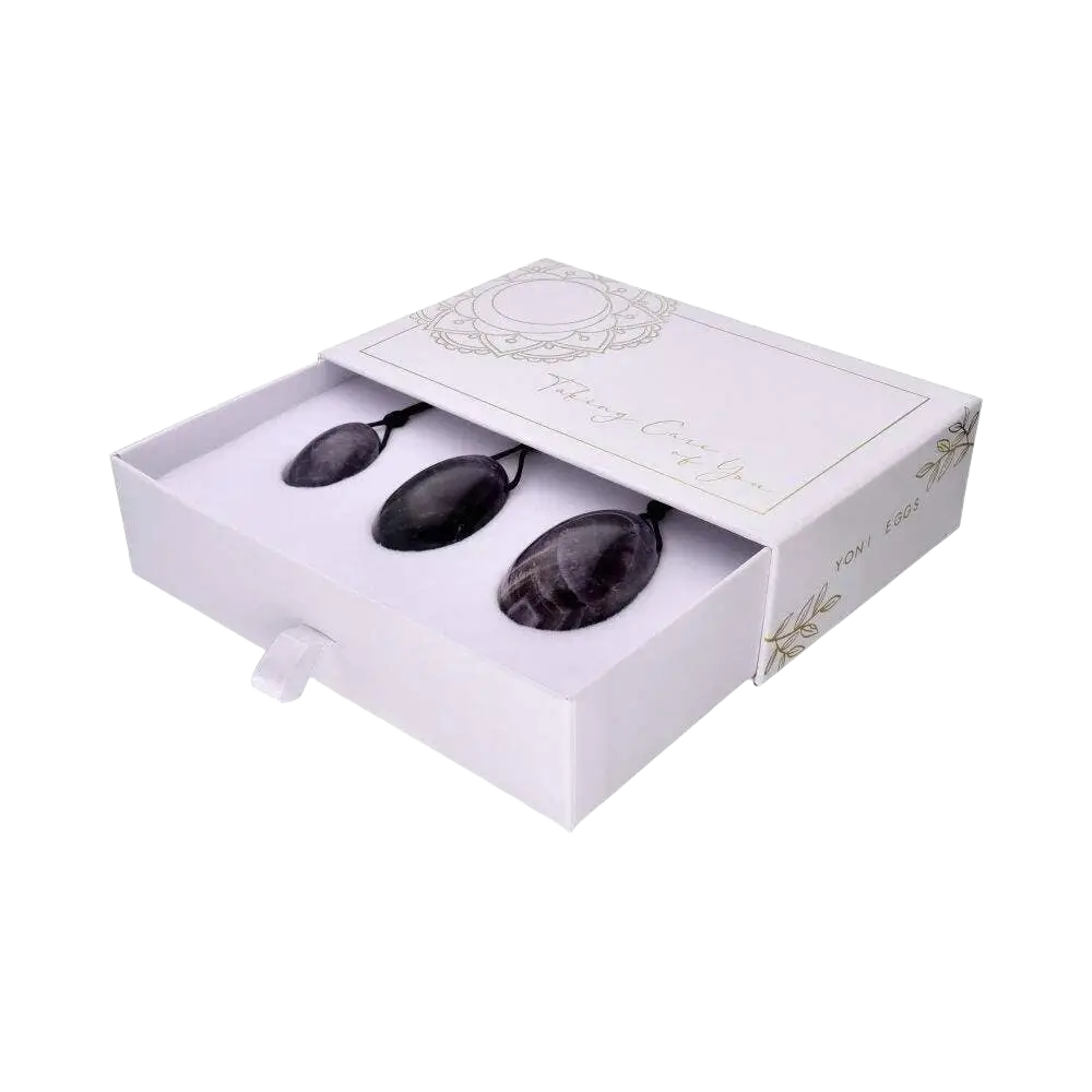 Drei Amethyst Yoni Eier aus Schmuck mit Loch und Schnur, elegant und handgefertigt, als spiritueller Schmuck und Accessoire.