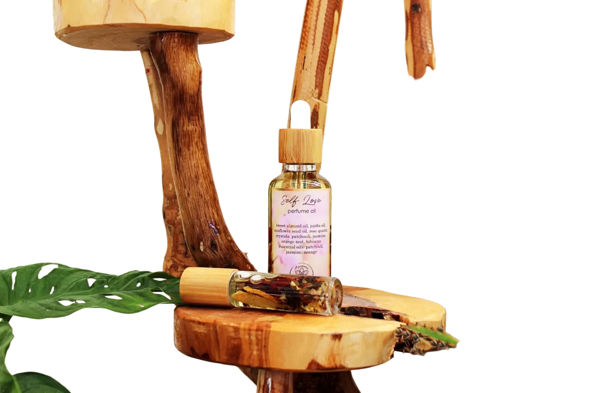 Ayamani Naturals Self Love Ritualöl mit Rosenquarz, ätherischen Ölen, als Parfüm- oder Badeöl, zeigt Flasche und Rosenquarz.