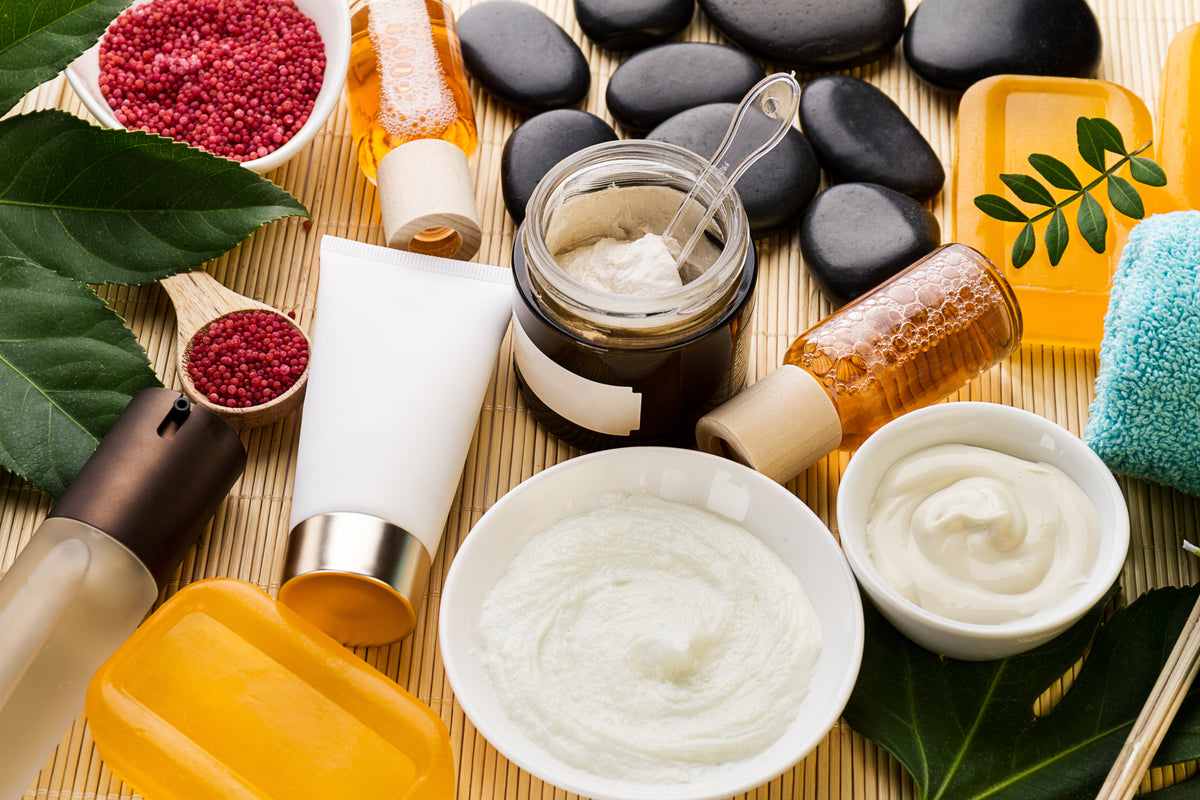 Bio-Kosmetik Produkte mit Cremes, Ölen und Natursteinen auf Bambusmatte