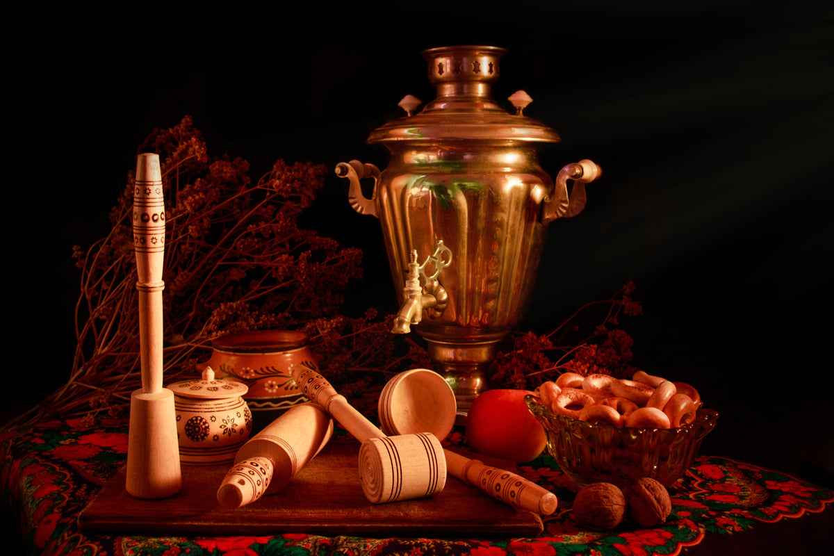 Traditionelles Samowar-Set mit Holzkunst mit Tee-Zubehör und Gebäck auf rustikalem Tisch.