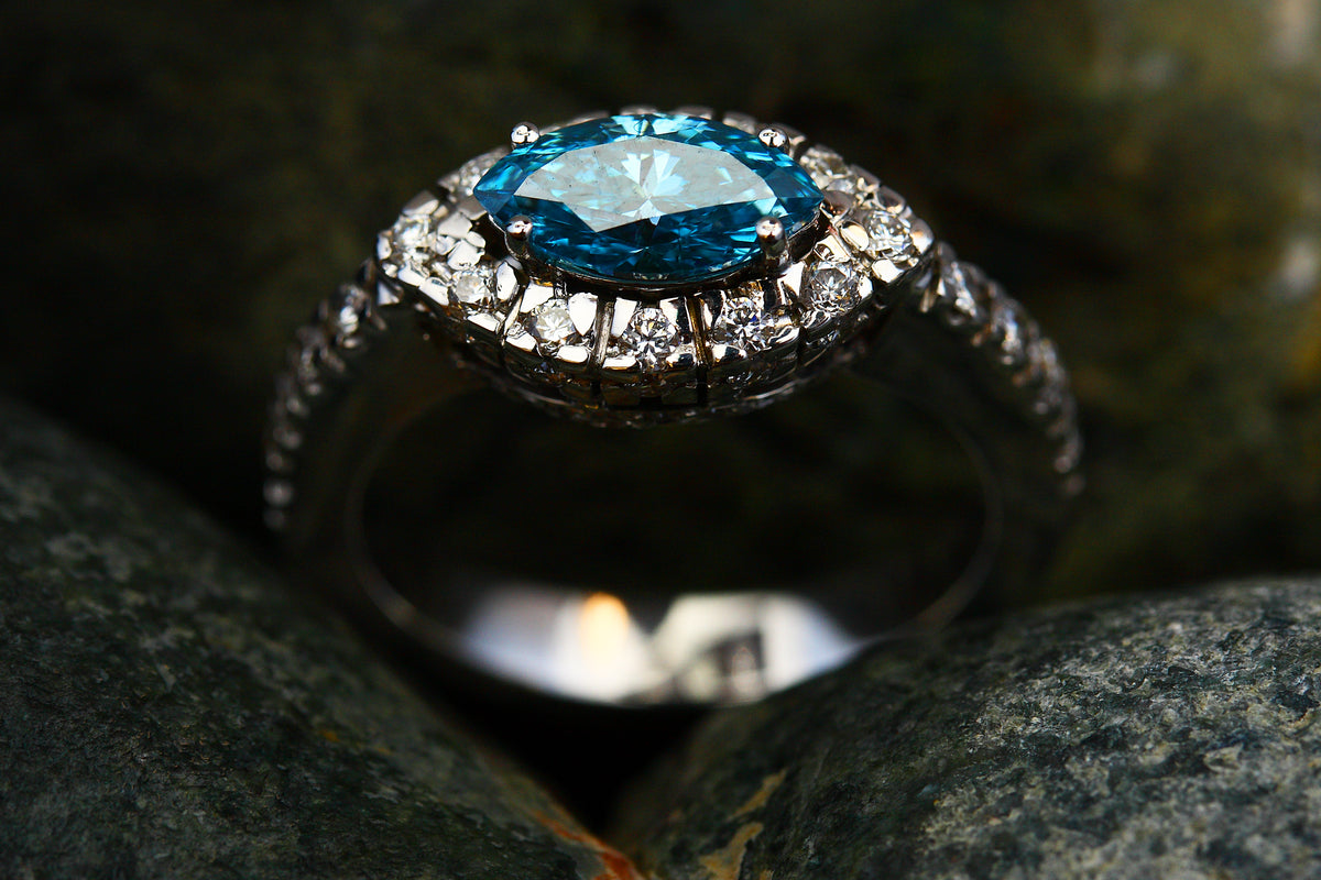 Edler Verlobungsring mit blauem Edelstein und Diamant-Halo in Silberfassung
