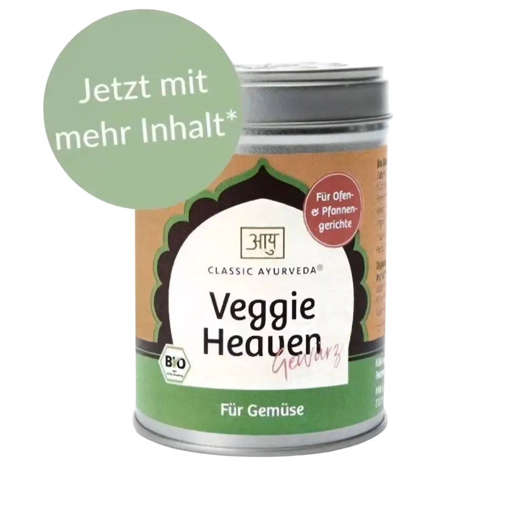 Bio-Gewürze von Classic Ayurveda, Veggie Heaven, in einem Gewürzglas mit buntem Gemüse im Hintergrund.