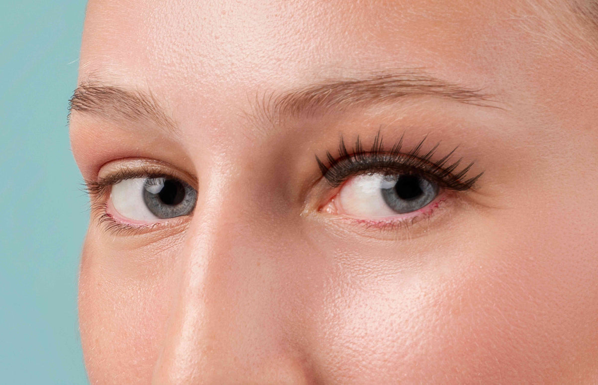 Nahaufnahme eines Gesichts mit betonten Wimpern und gepflegtem Augenbereich.