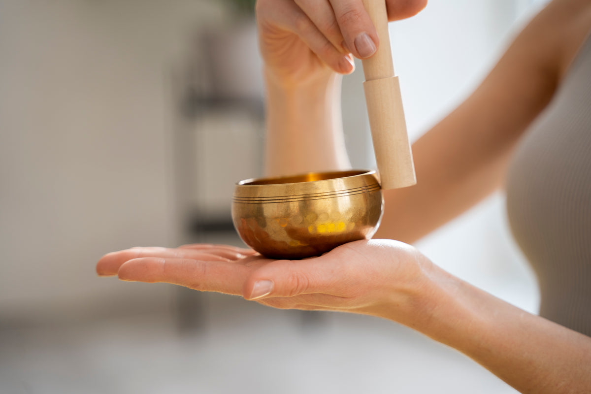 Goldene Klangschale für Yoga und Meditation in den Händen gehalten.