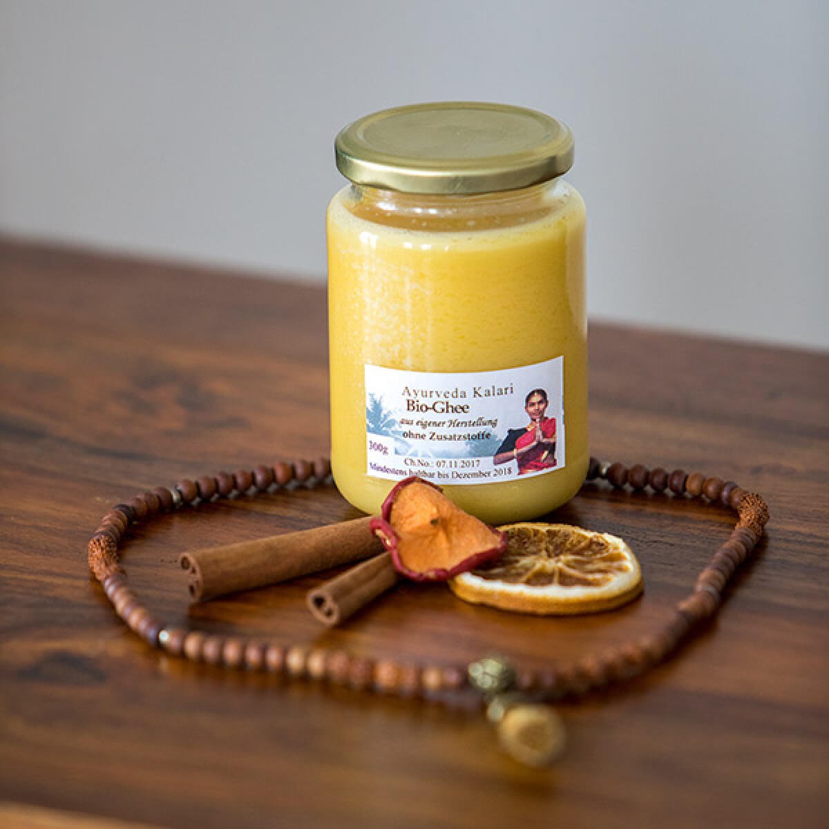 Eine golddeckelglas mit cremigem gelbem ayurveda kalı bio-ghee zur entdeckung hochwertiger öle im mana shop
