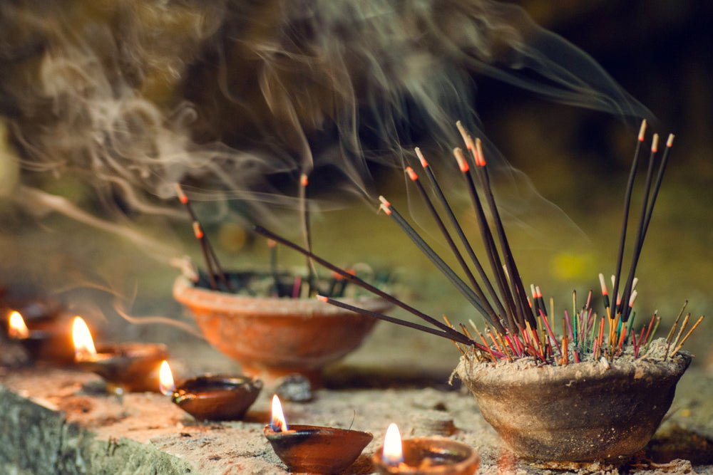 Ein rustikaler tonteller mit brennenden räucherstäbchen und rauch aus der kollektion entdecke aromatische räucherartikel