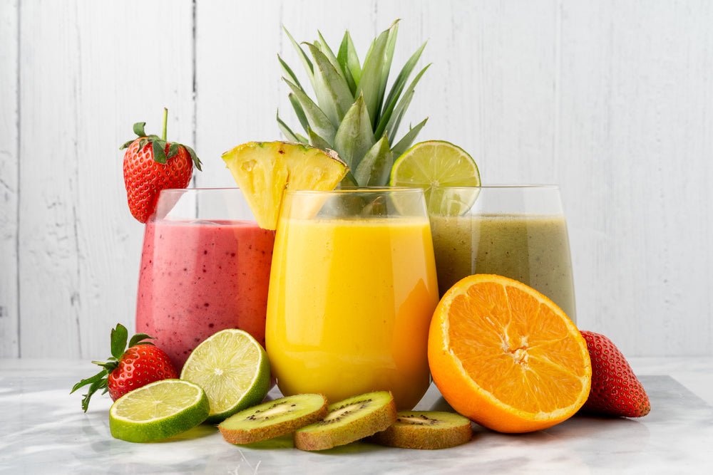 Drei bunte smoothies in klaren gläsern mit frischem obst als hochwertige natürliche getränke in der sammlung getränke