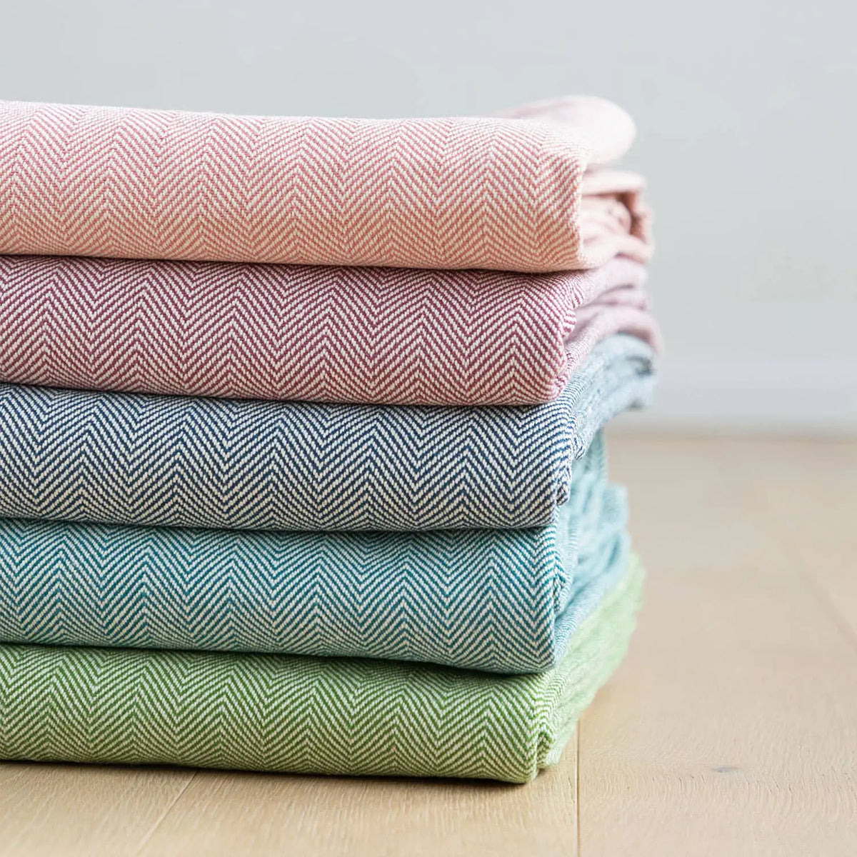 Stack von fünf gefalteten herringbone woll yoga decken in pastellfarben im mana shop bern ostermundigen kaufen