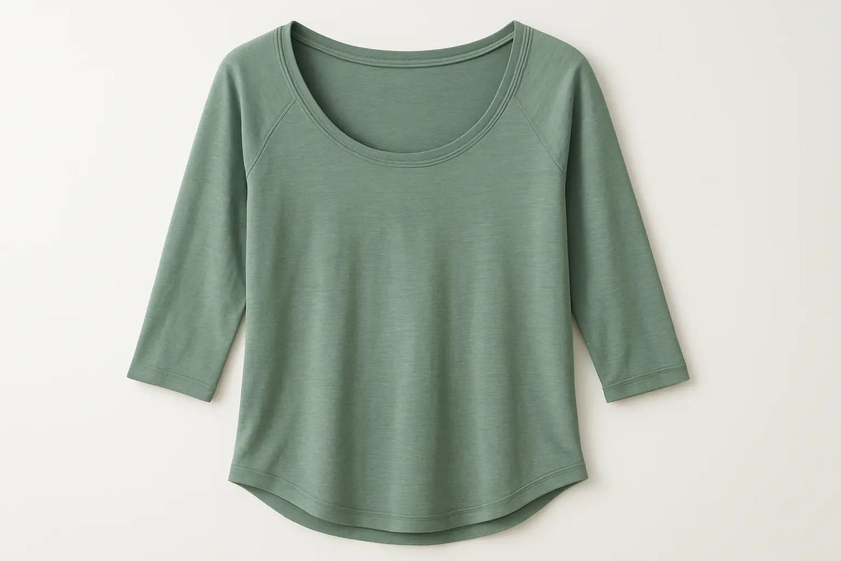 Ein weiches, salbeigrünes yoga shirt mit drei viertel ärmeln, lockerem sitz und langlebiger qualität im mana shop bern sortiment überzeugt