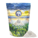 Eine Packung „Ancient Purity Pure Bicarbonate of Soda“ auf einem weißen Hintergrund, davor ein Haufen weißes Pulver.