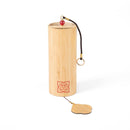 Ein hölzernes zylindrisches Windspiel mit einem violetten Chakra-Symbol.