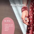 Eine Person mit einem roten Kleid, die viele Armbänder aus kleinen, roten Perlen trägt.