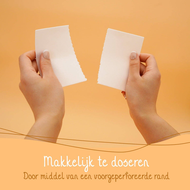 Eine Person zerreißt ein weißes Waschmittelblatt entlang einer perforierten Linie, mit niederländischem Text, der betont "Makkelijk te doseren Door middel van een voorgeperforeerde rand" (Einfach zu dosieren mittels einer vorgestanzten Kante).