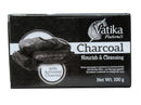 Eine rechteckige schwarz-weiße Schachtel der Seife "Vatika Naturals Charcoal Nourish & Cleansing". Sie zeigt Bilder von Aktivkohle und ein Feder-Design, mit der Angabe "Net Wt. 100 g".