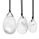 Set aus drei polierten, glatten, eiförmigen Klarquarz-Anhängern in verschiedenen Größen (groß, mittel, klein), die jeweils an einer geknoteten schwarzen Kordel hängen.