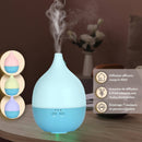 Ein elektrischer, blau-hellblauer tropfenförmiger Aroma-Diffusor, der Nebel ausstößt, mit drei Farbvarianten links und einer französischen Funktionsliste rechts.