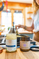 Gläser mit traditionellem Ghee und Tridoshic-Gewürzmischung auf einer Küchenzeile.