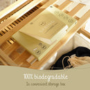 Verpackung für biologisch abbaubare Waschtücher mit der Aufschrift „Spring“ auf einer Holzoberfläche. Der Text darunter lautet: „100 % biologisch abbaubar in praktischer Aufbewahrungsbox.“ Warme Beleuchtung.