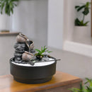 Ein kleiner Zimmer-Zen-Garten mit fließendem Wasserbrunnen, weißem Sand und einer Miniatur-Pagode.
