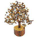 Ein kleiner Baum aus braunen Steinen auf einem Holzsockel.
