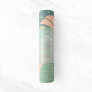 Draufsicht auf eine hellgrüne Yogamatte, die teilweise ausgerollt ist und ein tropisches Palmenblattmuster sowie die passende zylindrische „Palm Yoga Mat“-Verpackung zeigt.