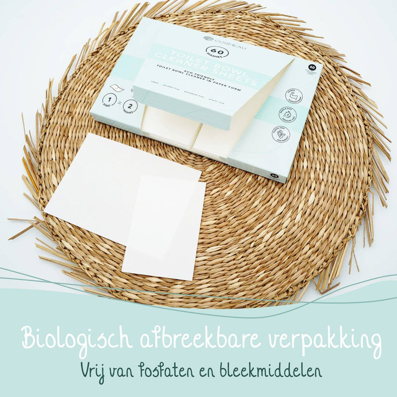 Eine Schachtel Cosmeau Toilettenreiniger-Blätter auf einer gewebten Matte, die hervorhebt, dass die "Biologisch afbreekbare verpakking" (biologisch abbaubare Verpackung) "Vrij van fosfaten en bleekmiddelen" (frei von Phosphaten und Bleichmitteln) ist.