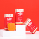 Hautpflegeprodukte von Koji White auf orangefarbenem Hintergrund.