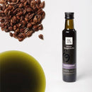 Eine Flasche Traubenkernöl (Oleum Vitis vinifera) von Ölwerk steht rechts auf weißem Grund, mit einem Haufen dunkler Traubenkerne in der oberen linken Ecke und einem verschwommenen Tropfen des grün-gelben Öls im unteren linken Bereich. Das Etikett der Flasche bewirbt "feinste biologische Öle" und "100% rein & naturbelassen".