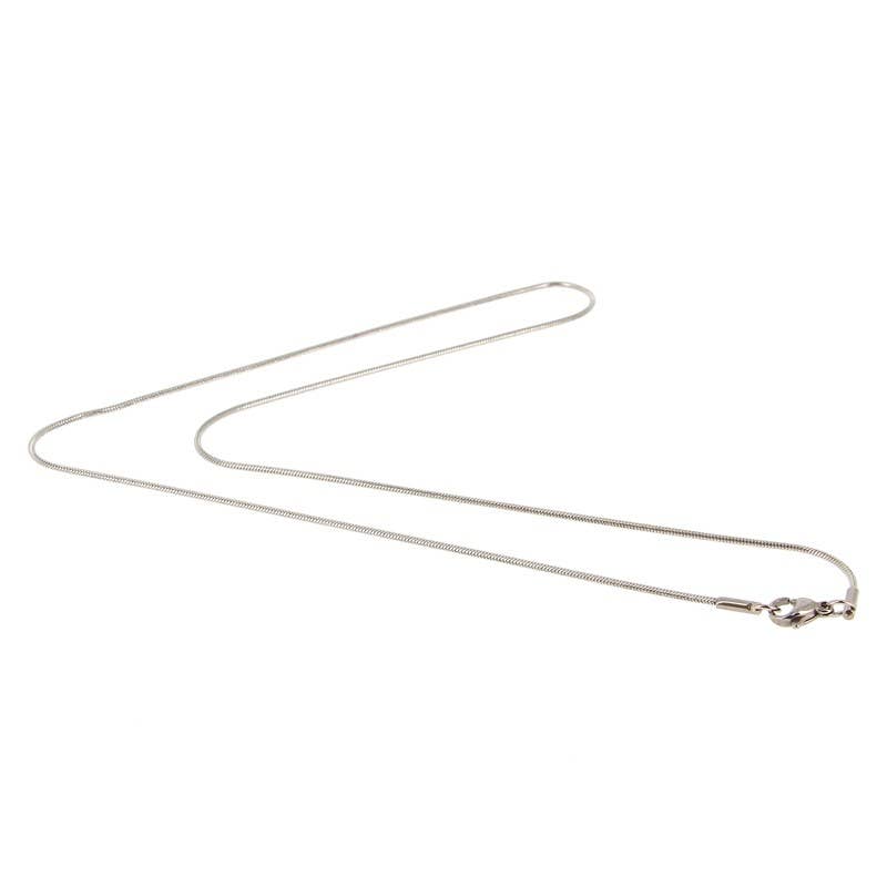 Dünne, polierte silberfarbene Schlangenkette, die in einer sanften Kurve liegt und den Verschluss an einem Ende zeigt.