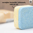 Nahaufnahme einer blau-gelben Reinigungstablette mit Text über die Entfernung von Keimen und Schmutz.