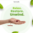Eine Hand hält ein rotes Gummibärchen, was impliziert, dass es "Lecker" ist, umgeben von dem Text "Relax. Restore. Unwind.".