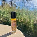 Eine Roll-on-Flasche Paavani Ayurveda Women's Moon Oil zur Unterstützung des weiblichen Zyklus, draußen vor einem verschwommenen Hintergrund aus Gras und Himmel fotografiert.
