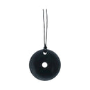 Ein glatter, runder schwarzer Anhänger mit einem Loch in der Mitte, der an einer schwarzen Schnur hängt.