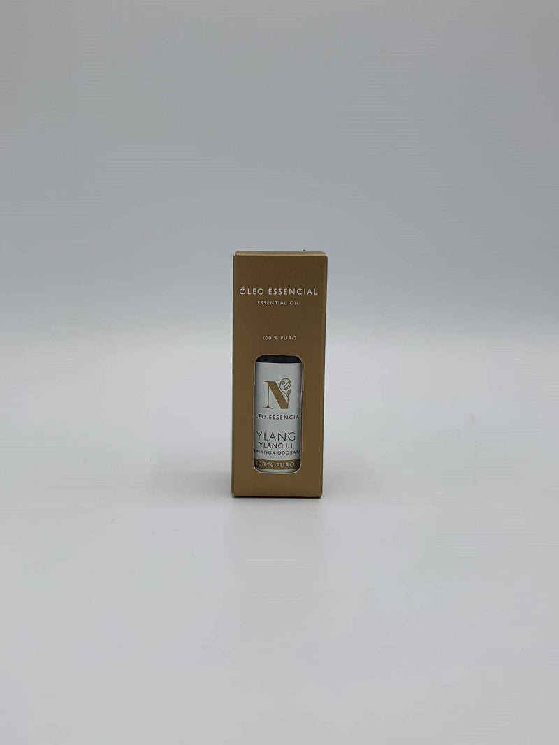 Kleine braune Pappschachtel mit einer Flasche Ylang-Ylang-Öl.