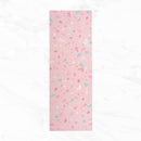 Eine Draufsicht auf eine hellrosa Yogamatte, die auf einer weißen Marmoroberfläche ausgerollt ist und ein buntes Muster im Terrazzo-Stil mit blauen, weinroten und weißen Akzenten zeigt.