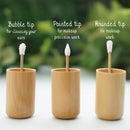 Drei wiederverwendbare Bambus-Wattestäbchen in Bambushaltern, zeigen verschiedene Spitzen: Blasen-Spitze zur Ohrreinigung, spitze Spitze für präzises Make-up und abgerundete Spitze für allgemeine Make-up-Arbeiten.