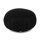 Ein runder schwarzer Meditationskissen mit vertikalen Falten an der Seite. Das Kissen wird aus einem seitlichen Winkel gezeigt, wodurch seine Form und Textur hervorgehoben werden. Ein kleines Etikett ist am Boden sichtbar.