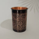 Ein Becher aus reinem Kupfer mit dunklem Antik-Finish und einem detaillierten, geprägten floralen Rankenmuster.