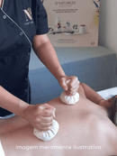 Therapeut gibt eine Rückenmassage mit zwei Kräuterstempeln.
