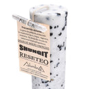 Nahaufnahme einer schwarz-weiß gesprenkelten Kerze mit einem Papieranhänger.