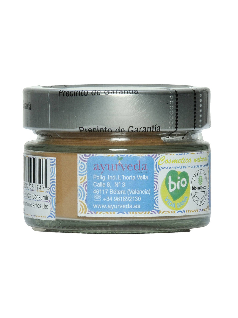 Ein braunes Pulverglas mit einer blauen Etikette, die den Markennamen "ayurveda", Adresse, Telefonnummer und Website zeigt. Rechts ist ein grünes "bio" Logo und ein "CERTIFIED bio.inspecta" Siegel zu sehen.