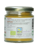 Das rückseitige Etikett eines Glasgefäßes mit "Ayurveda autentico Curry" aromatischem Gewürz. Es listet Zutaten wie Koriander, Kurkuma, Knoblauch, Chili, Meersalz, Ingwer, Kreuzkümmel, Bockshornklee, schwarzer Pfeffer, Sellerie und Zwiebeln auf und weist auf die Verwendung als natürliches Farbmittel in der Gastronomie für Gerichte wie Reis, Eintöpfe und Salate hin.