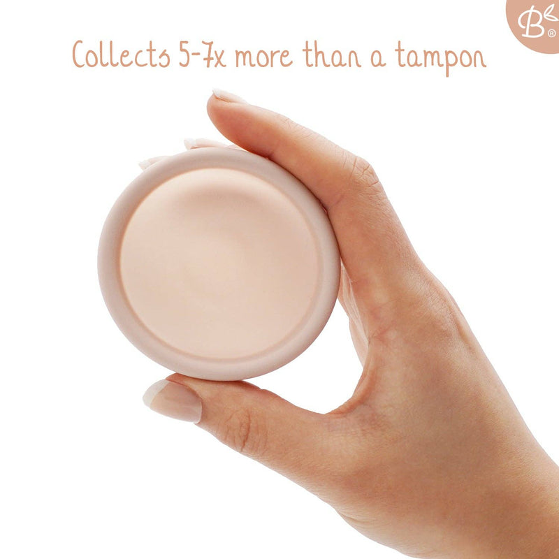 Eine Hand hält eine rosa Menstruationsscheibe, wobei der Text hervorhebt, dass sie "5-7x mehr als ein Tampon sammelt".
