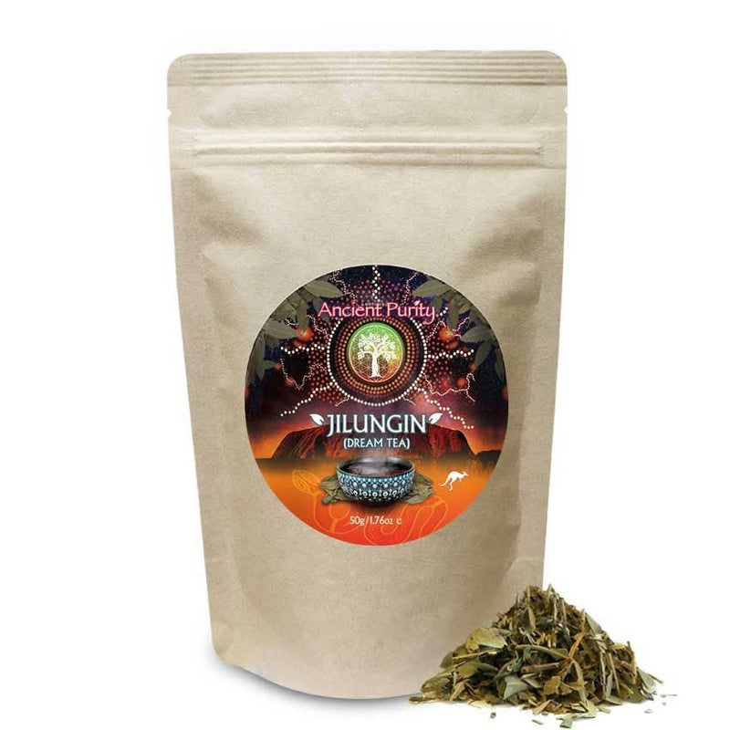 Ein brauner Papierbeutel mit "Ancient Purity Jilungi (Dream Tea)" und einem runden Etikett. Das Etikett zeigt eine sternenklare Nachtlandschaft mit einem Baum, und vor dem Beutel liegt ein kleiner Haufen loser Teeblätter.