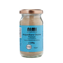 Ein Glas NIMI AYURVEDA Avipattikara Churna Premium, eine ayurvedische Gewürzpulverzubereitung, mit einem hellbraunen Deckel und einem blauen Etikett, auf dem der Inhalt von 100 g, die Aufschrift „Vegan“ und das BDIH-Zertifizierungslogo stehen.
