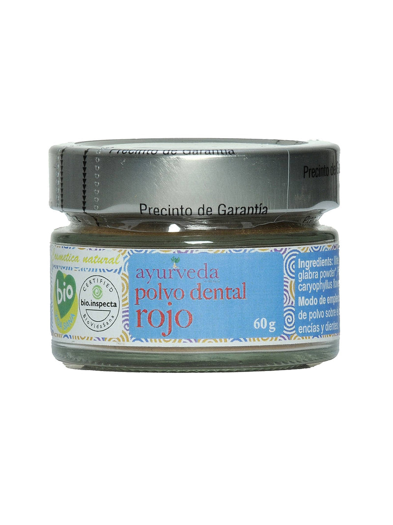 Ein braunes Pulverglas mit einem blauen Etikett, das "ayurveda polvo dental rojo" und 60g Inhalt angibt. Rechts sind die Inhaltsstoffe und Anwendungshinweise zu sehen.